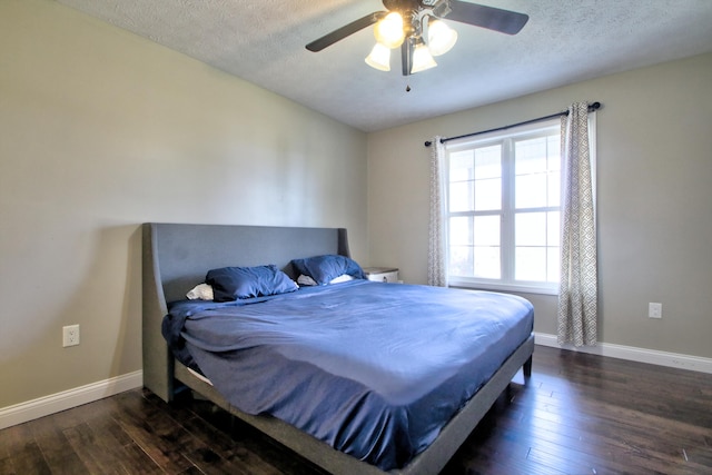 bedroom featuring ceiling fan, a textured ceiling, and dark hardwood / wood-style flooring