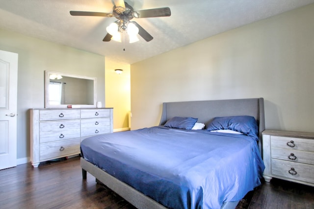 bedroom with ceiling fan, a textured ceiling, and dark hardwood / wood-style flooring