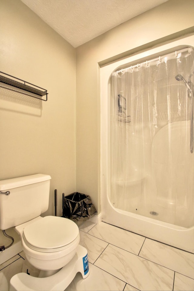 bathroom with toilet, a textured ceiling, and a shower with curtain