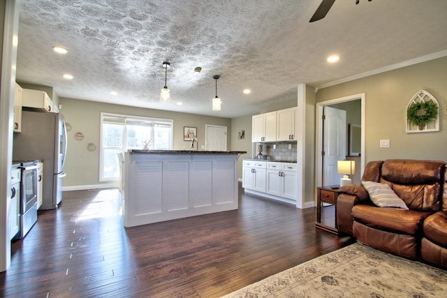 kitchen featuring a kitchen island, pendant lighting, white cabinets, stainless steel range oven, and dark hardwood / wood-style flooring