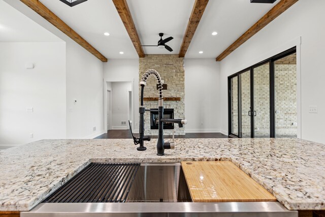 kitchen with hanging light fixtures, white cabinetry, and an island with sink