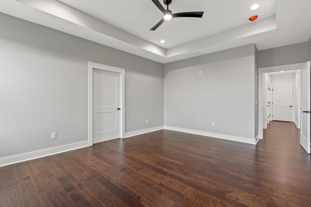 bedroom featuring dark wood-type flooring, ceiling fan, and a raised ceiling