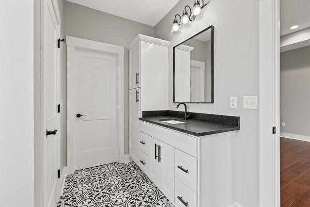 bathroom with tile patterned flooring, a bathing tub, and vanity