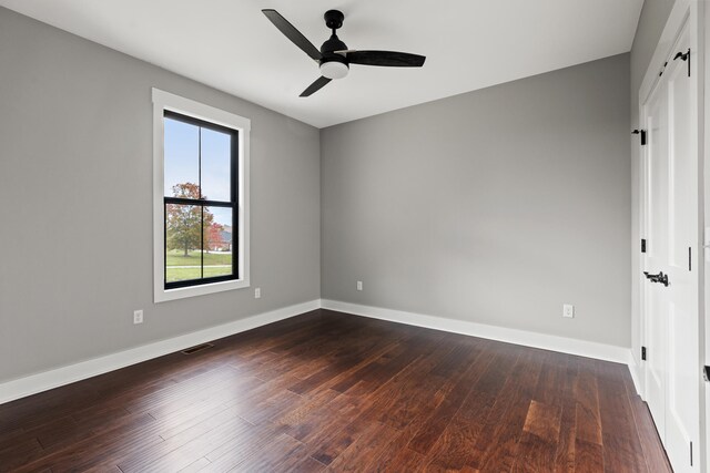 unfurnished bedroom featuring dark hardwood / wood-style flooring, ceiling fan, and a closet