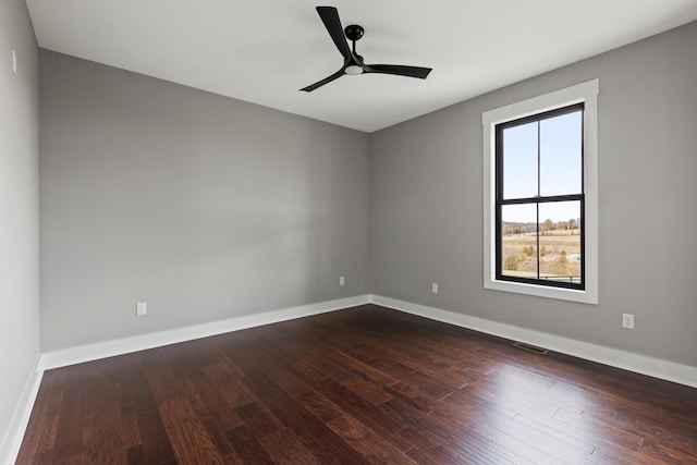 unfurnished room featuring dark wood-type flooring and ceiling fan