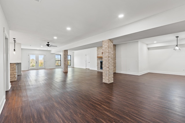 unfurnished living room with ceiling fan, dark wood-type flooring, and a fireplace