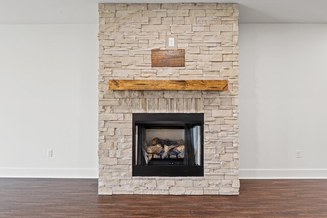 unfurnished living room with a brick fireplace, dark wood-type flooring, and ceiling fan