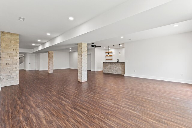 unfurnished living room featuring a fireplace, dark hardwood / wood-style floors, and ceiling fan