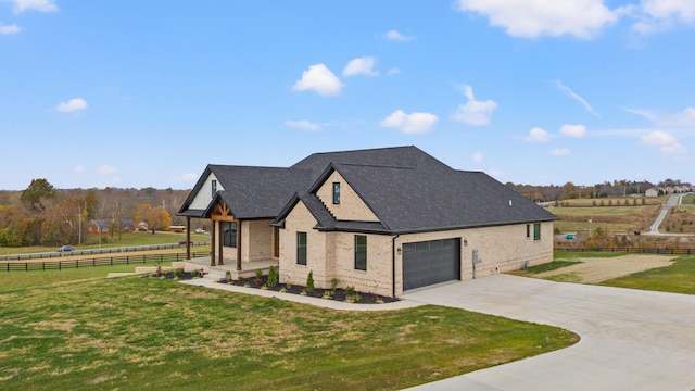 view of front of home featuring a garage, a rural view, and a front lawn