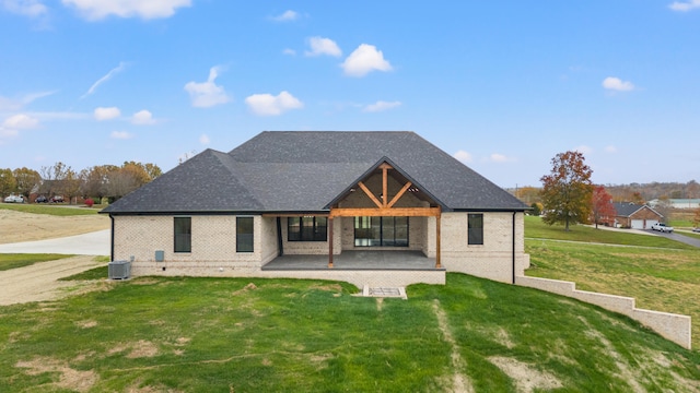 back of property with central AC unit, a lawn, and a patio