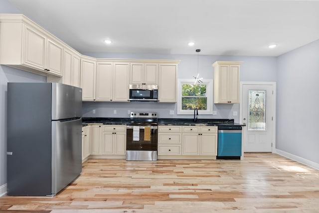 kitchen featuring light hardwood / wood-style floors, cream cabinets, stainless steel appliances, and sink