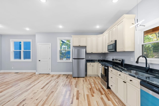 kitchen with a wealth of natural light, sink, stainless steel appliances, and light wood-type flooring