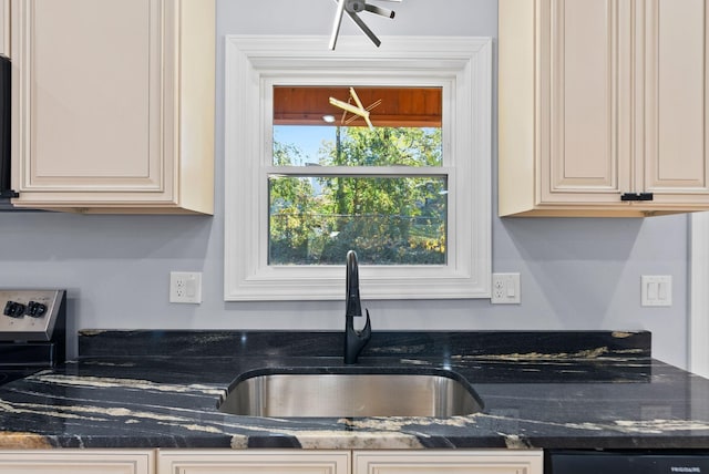 kitchen featuring black dishwasher, sink, and dark stone counters