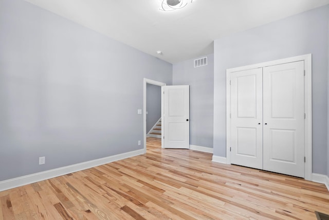 unfurnished bedroom featuring light hardwood / wood-style flooring and a closet