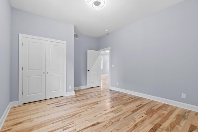 unfurnished bedroom featuring a closet and light wood-type flooring