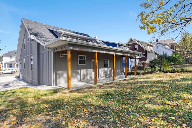 rear view of property with a yard and a patio area