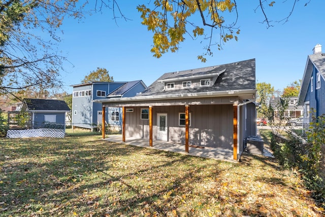 back of property with a yard and a patio area