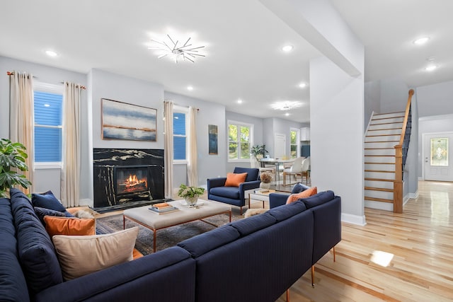 living room with light hardwood / wood-style flooring and a high end fireplace