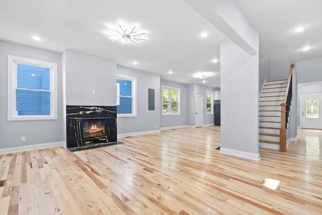 unfurnished living room with light hardwood / wood-style flooring and a high end fireplace