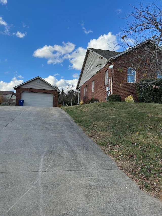 view of side of property featuring a garage and a lawn