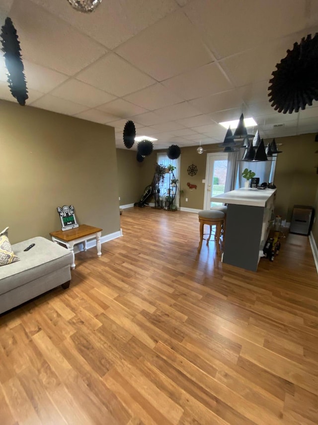 interior space featuring a drop ceiling and light hardwood / wood-style floors