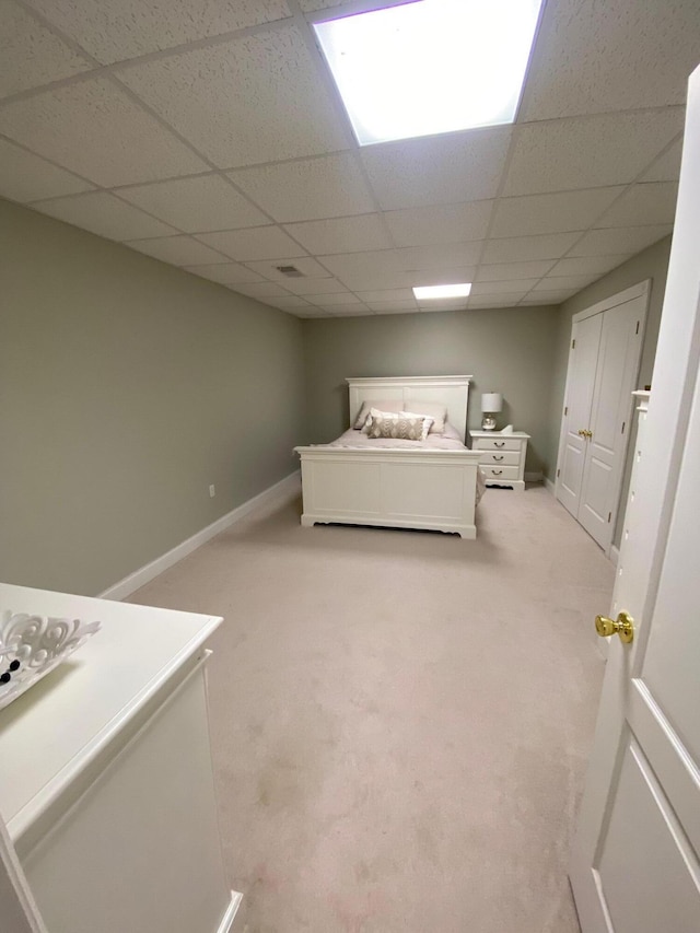 unfurnished bedroom with light carpet and a drop ceiling