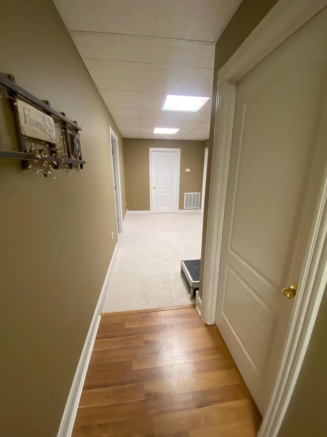 hallway featuring hardwood / wood-style floors and a paneled ceiling