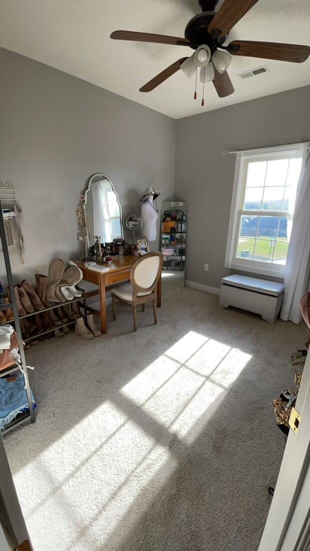 unfurnished office featuring ceiling fan and carpet floors