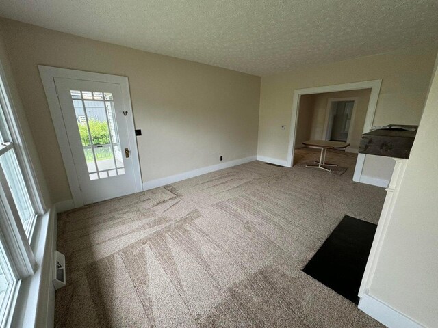 interior space featuring a textured ceiling and carpet