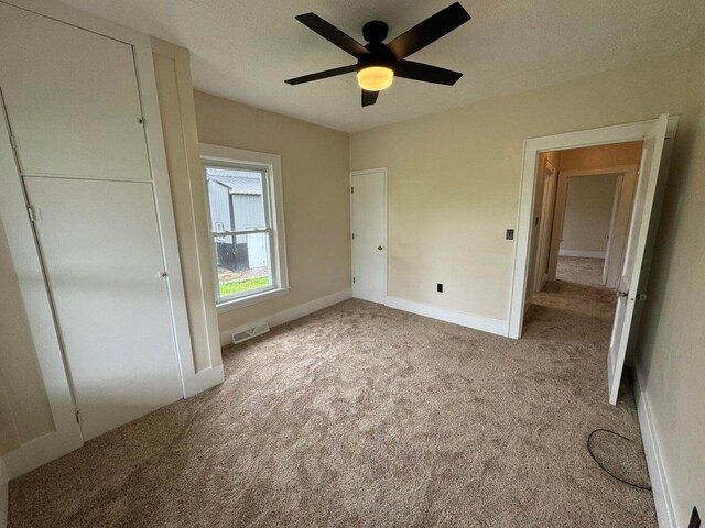 unfurnished bedroom with light carpet and ceiling fan