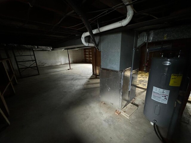 basement featuring electric water heater and heating unit