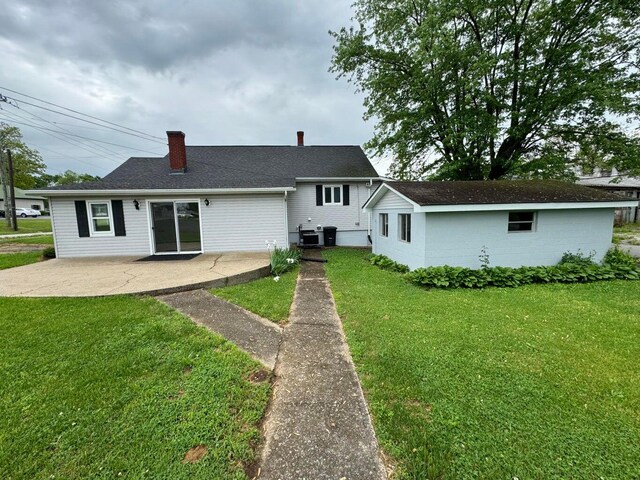 rear view of house featuring a yard and a patio