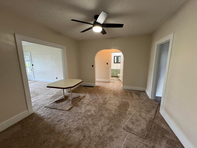 carpeted spare room with a textured ceiling and ceiling fan