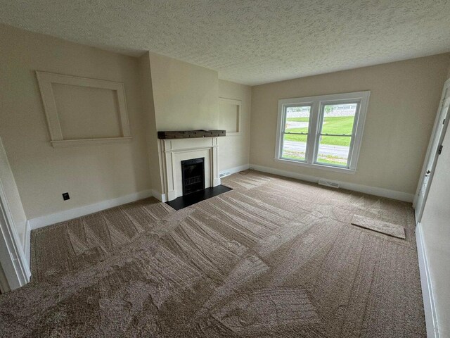 unfurnished living room with light carpet and a textured ceiling