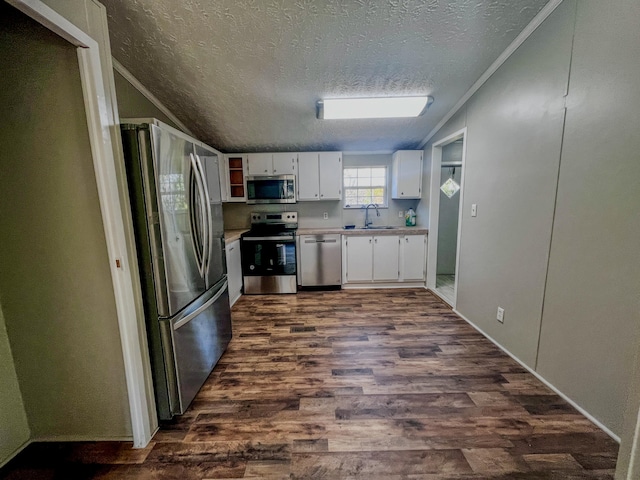 kitchen with white cabinetry, stainless steel appliances, dark hardwood / wood-style floors, and crown molding