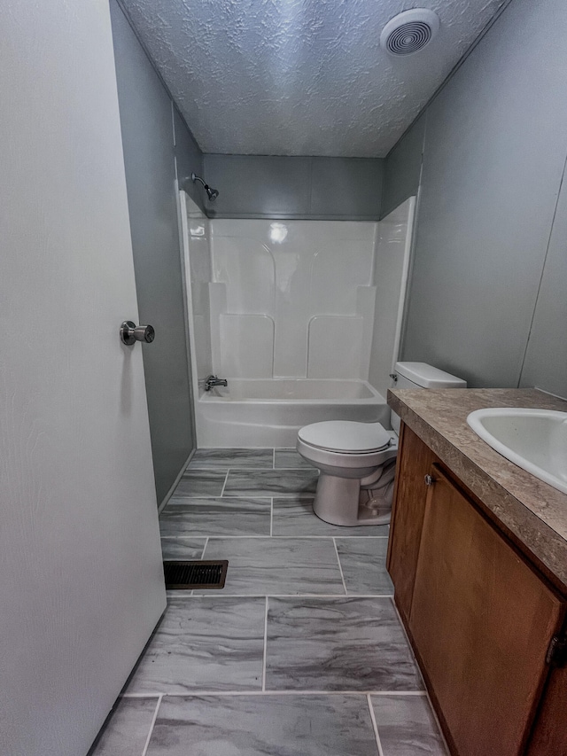 full bathroom with shower / bathing tub combination, vanity, a textured ceiling, and toilet