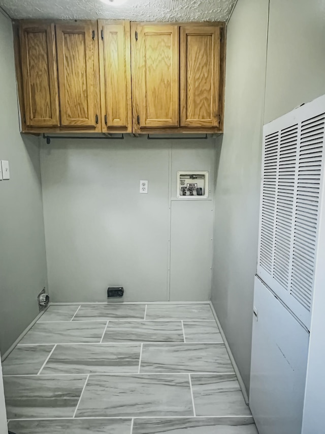 laundry area featuring cabinets, hookup for a washing machine, and a textured ceiling