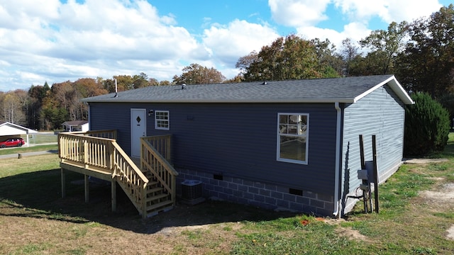 rear view of property featuring central AC unit and a yard