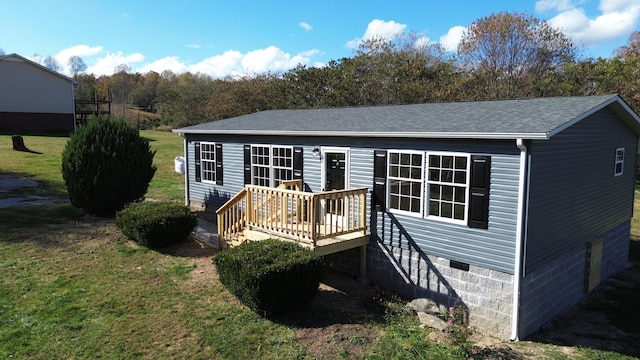 rear view of property with a wooden deck and a yard