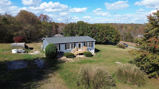 single story home with a front yard and an outbuilding