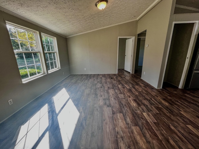 empty room featuring a textured ceiling, lofted ceiling, dark hardwood / wood-style floors, and crown molding