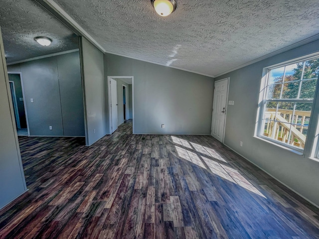 spare room featuring a textured ceiling, lofted ceiling, dark hardwood / wood-style floors, and crown molding