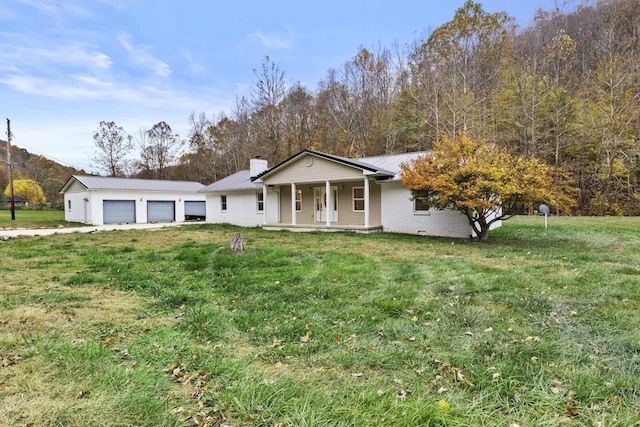 223 Sycamore Rd, Stanton, KY 40380 - view of front facade with covered porch, an attached garage, metal roof, a front lawn, and a chimney