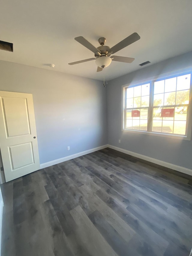 spare room featuring ceiling fan and dark wood-type flooring