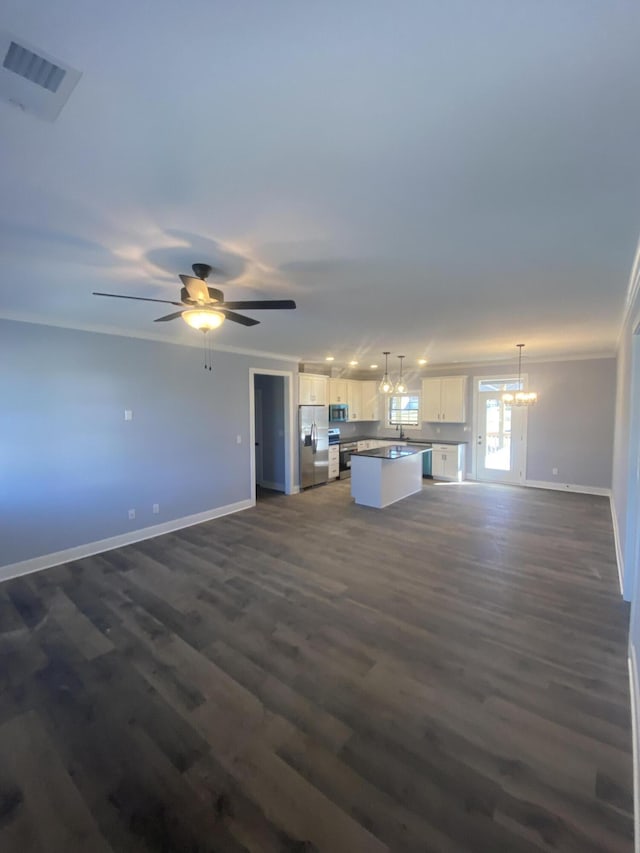 unfurnished living room featuring dark wood-style floors, visible vents, crown molding, and baseboards