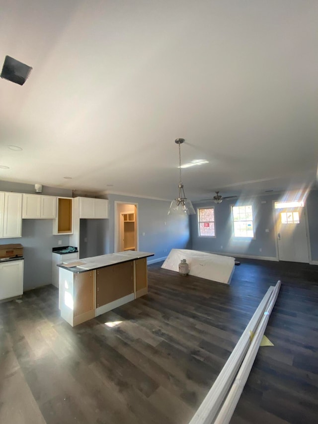 kitchen featuring dark hardwood / wood-style flooring, a center island, white cabinets, and hanging light fixtures