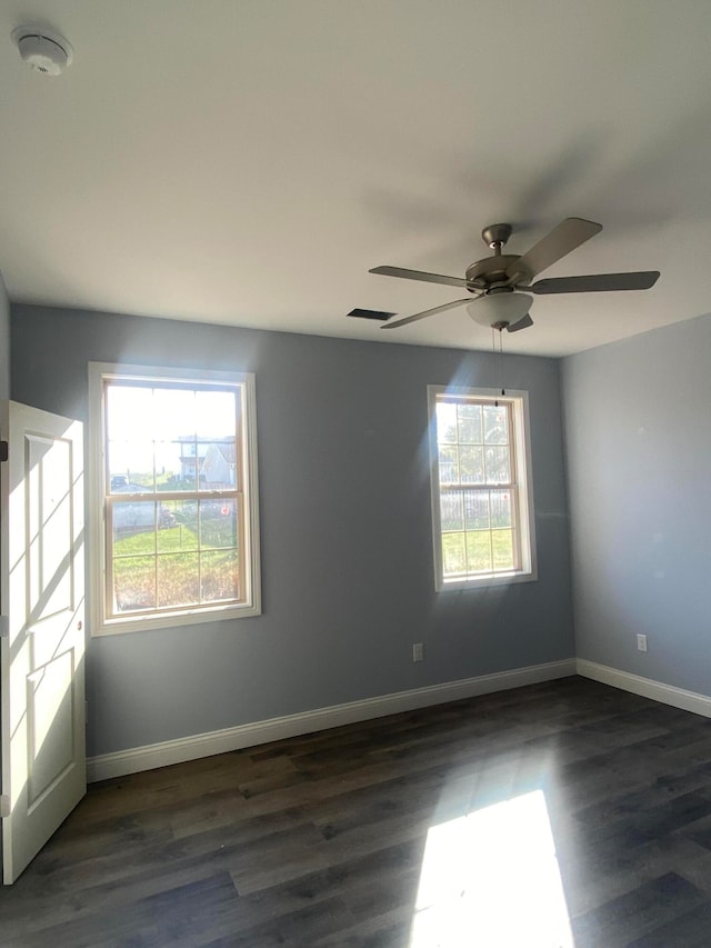 empty room with ceiling fan and dark wood-type flooring