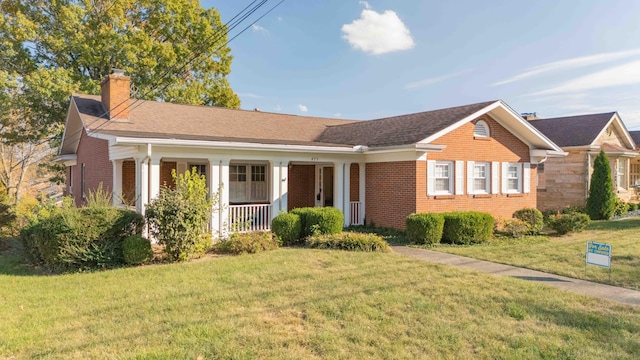 ranch-style home featuring covered porch and a front yard