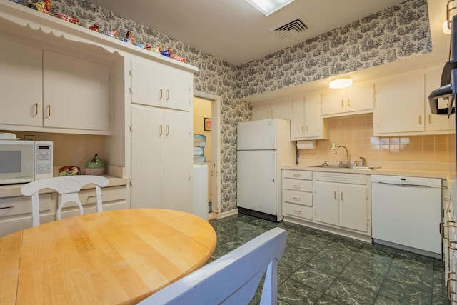 kitchen featuring white cabinets, white appliances, sink, and backsplash