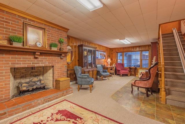 living room with wood walls, carpet, and a fireplace